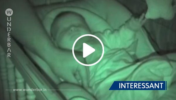 Vater bedeckt die kalten Hände des Babies mit der Decke – doch dann fängt die Kamera etwas Eigenartiges ein