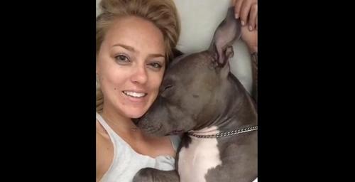 Eine Hundebesitzerin wird von ihrem Pitbull mit Küssen überschüttet, als er aufwacht