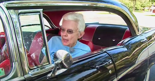 Eine Frau zeigt ihren alten Chevrolet, das einzige Auto, das sie seit dem Neukauf 1957 gefahren hat