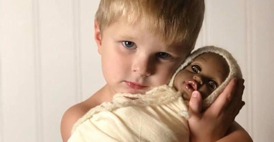 Ein 4-jähriger Junge hat ein Fotoshooting mit seiner Lieblingspuppe