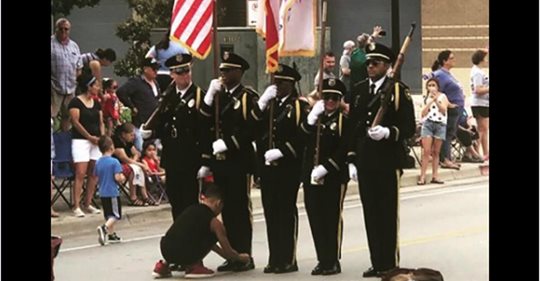 10-jähriger Junge hilft Soldaten der Ehrengarde während der Prozession beim Schnürsenkelbinden