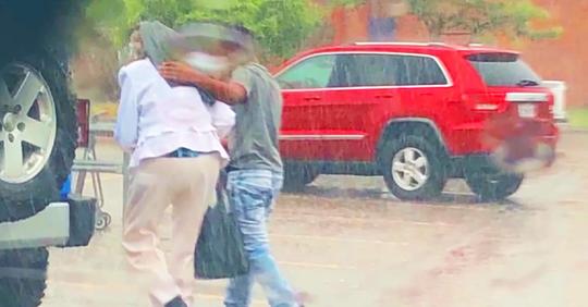 Jugendlicher schützt ältere Dame vor Regen, unbewusst, dass die Polizei ihn und seine Familie dafür anhalten wird