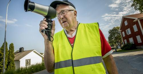 Alter Mann benutzt einen Haarföhn als Radargerät, um die Autos, die zu schnell unterwegs sind, langsamer fahren zu lassen